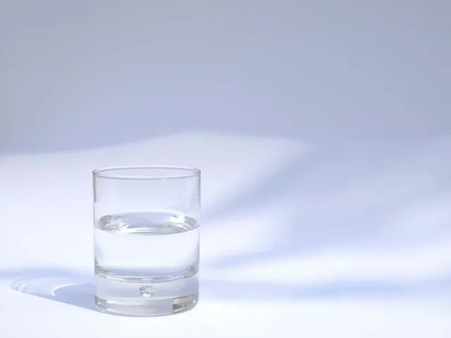 Glass of water with hydration tips for daily intake