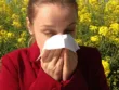 Person blowing their nose during seasonal allergies and sinus congestion